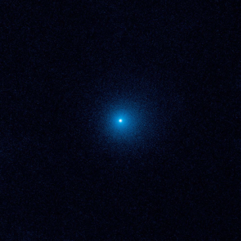 To zdjęcie z Kosmicznego Teleskopu Hubble’a pokazuje rozmyty obłok pyłu, zwany komą, otaczający kometę C/2017 K2 PANSTARRS (K2), najdalszą aktywną kometę kiedykolwiek zaobserwowaną, wchodzącą do Układu Słonecznego. Hubble wykonał zdjęcia K2, gdy zamarznięty gość znajdował się ponad 2,4 miliarda kilometrów od Słońca, tuż za orbitą Saturna. Nawet z tej odległej odległości światło słoneczne ogrzewa mroźną kometę, wytwarzając komę o szerokości 128 000 kilometrów, która otacza maleńkie, stałe jądro. K2 podróżuje od milionów lat ze swojego domu w Obłoku Oorta, sferycznym regionie na skraju naszego Układu Słonecznego. Ten mroźny obszar zawiera setki miliardów komet, lodowych pozostałości po powstaniu Układu Słonecznego 4,6 miliarda lat temu. Zdjęcie zostało zrobione w czerwcu 2017 roku przez szerokokątną kamerę Hubble’a 3