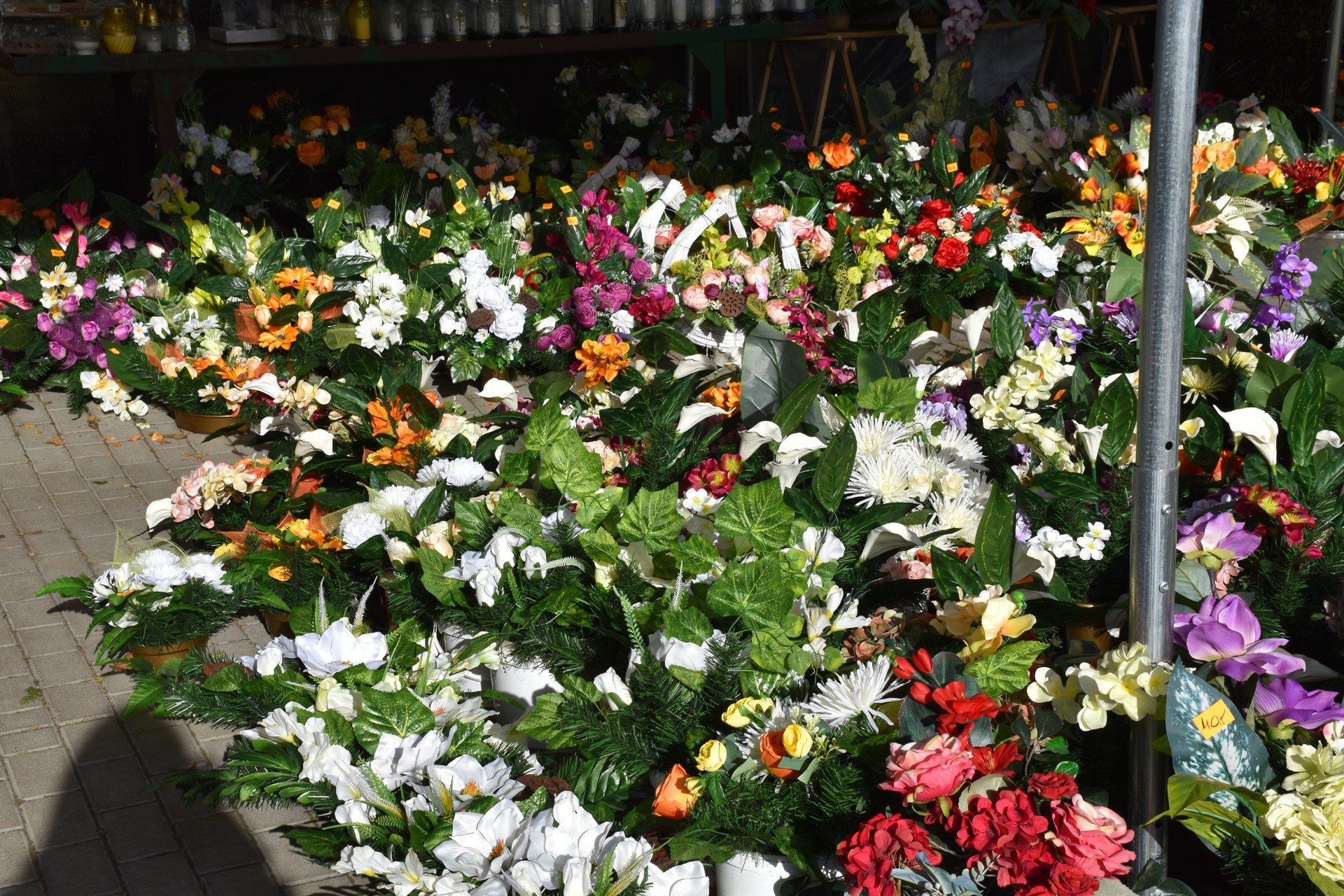 Wiele osób zdecydowało się zamówić kompozycje wcześniej w kwiaciarniach, ale przy cmentarzu można liczyć też na gotowe sztuczne wiązanki i zestawy kwiatów.