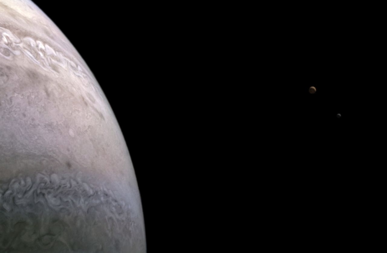 Na przybliżeniu można zauważyć dwa obiekty znajdujące się w oddali. Są to dwa księżyce Jowisza.