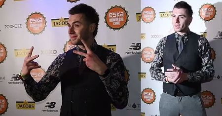 Elegancki Kamil Bednarek zaciska dłonie na ściance