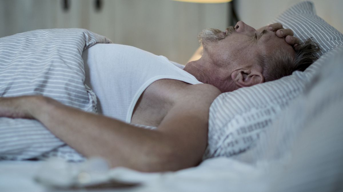Senior man in his early 60s with greying beard is sick and sleepless in bed while night.EMS-FORSTER-PRODUCTIONSmegrim, migraine, bad dream, sickness