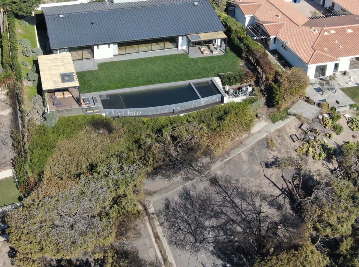 Matthew Perry's house, burnt trees and grass are visible around it.