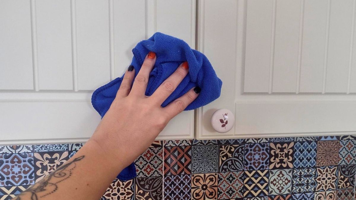 Kobieta czyści szafkę w kuchni