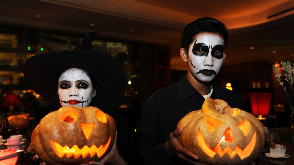 SURABAYA, INDONESIA - OCTOBER 31:  Revelers pose with jack-o'-lanterns at a Halloween party at Sheraton Surabaya Hotel on October 31, 2013 in Surabaya, Indonesia.  Revelers across the country are celebrating Halloween the day before the Christian All Saints' Day, which  honors the dead.  (Photo by Robertus Pudyanto/Getty Images)