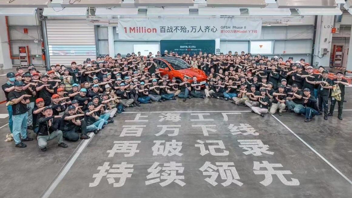 Pracownicy świętowali osiągnięcie wokół czerwonego modelu Y