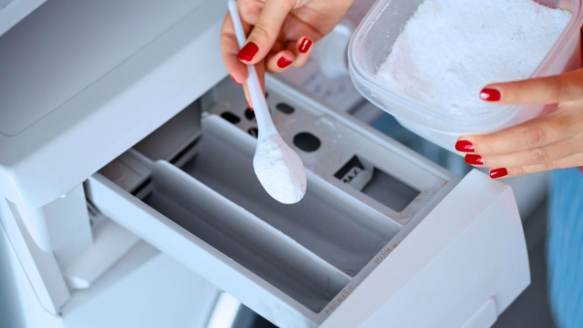 Kobieta wsypuje detergent do pralki