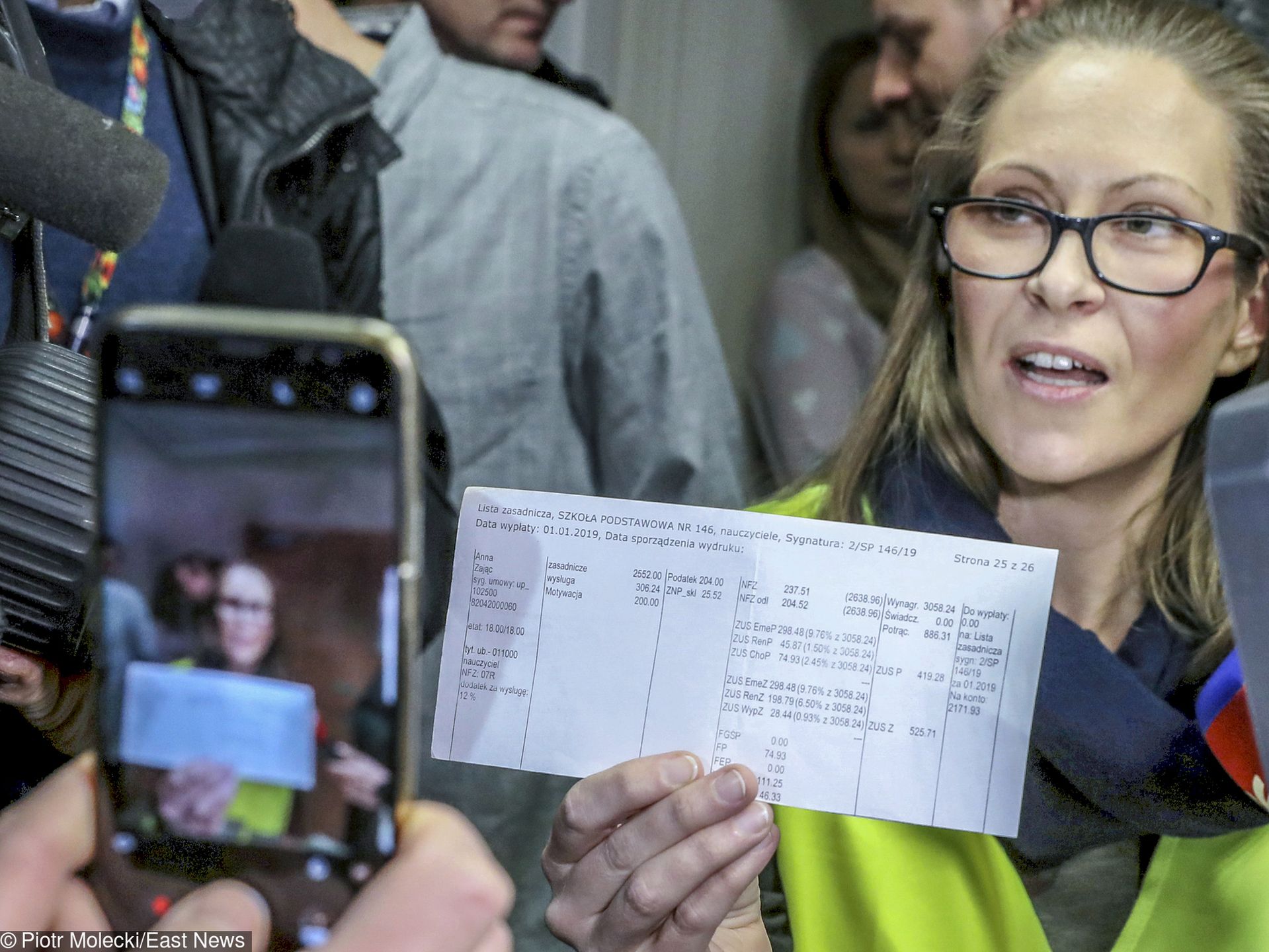 Anna Zając tłumaczy, dlaczego nauczyciele będą strajkować. Prezentuje zestawienie swoich wynagrodzeń. Ma potrójny tytuł magistra, w szkole uczy j. angielskiego. Zarabia niecałe 2200 zł na rękę. Jest członkiem ZNP.