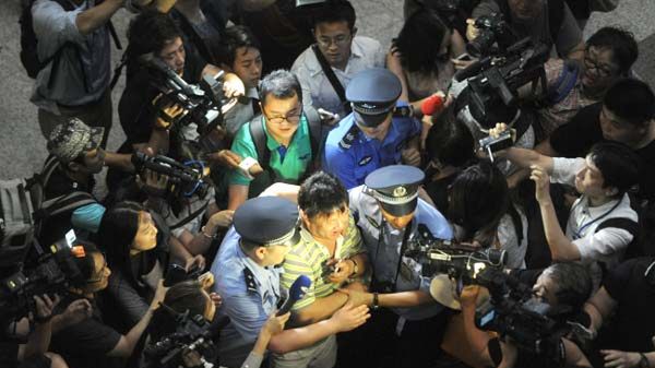 Policja eskortuje świadka eksplozji przed halą przylotów w Pekinie