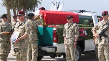 Dowódca Wielonarodowej Dywizji gen. Skrzypczak dekoruje trumnę z ciałem