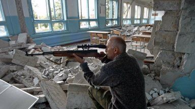 Żołnierz w budynku naprzeciw okupowanej szkoły