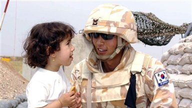 Południowokoreański żołnierz z małą Irakijką