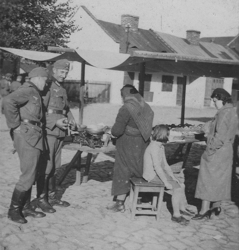 Uśmiechnięci żołnierze niemieccy na targowisku. Fotografia wykonana na ziemiach polskich w latach wojny. 