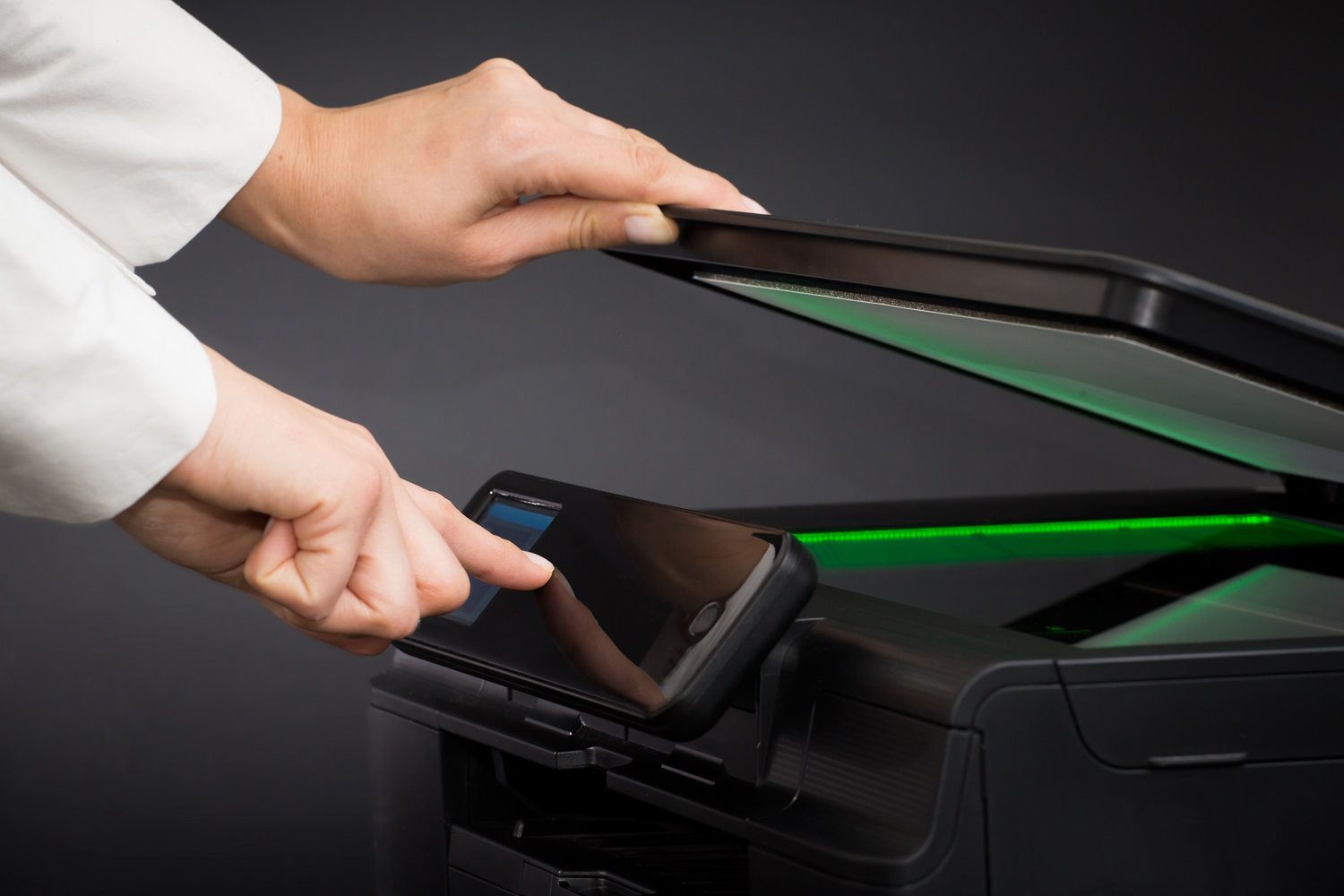 Woman using scanner multifunction device on black background.