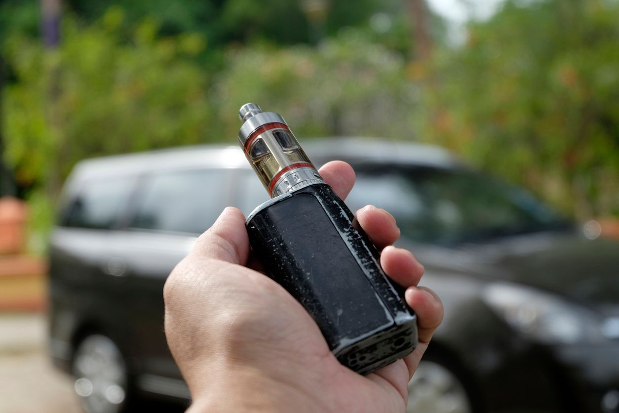 hand holding e-cigarette over blur background