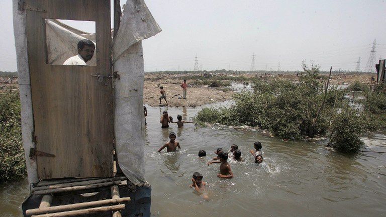 Toaleta w indyjskich slumsach, nieczystości wpadają wprost do wody, w której kąpią się dzieci