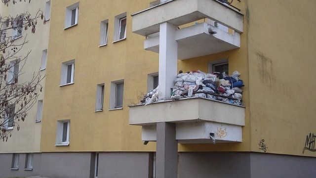 Balkon uginający się od stosu śmieci