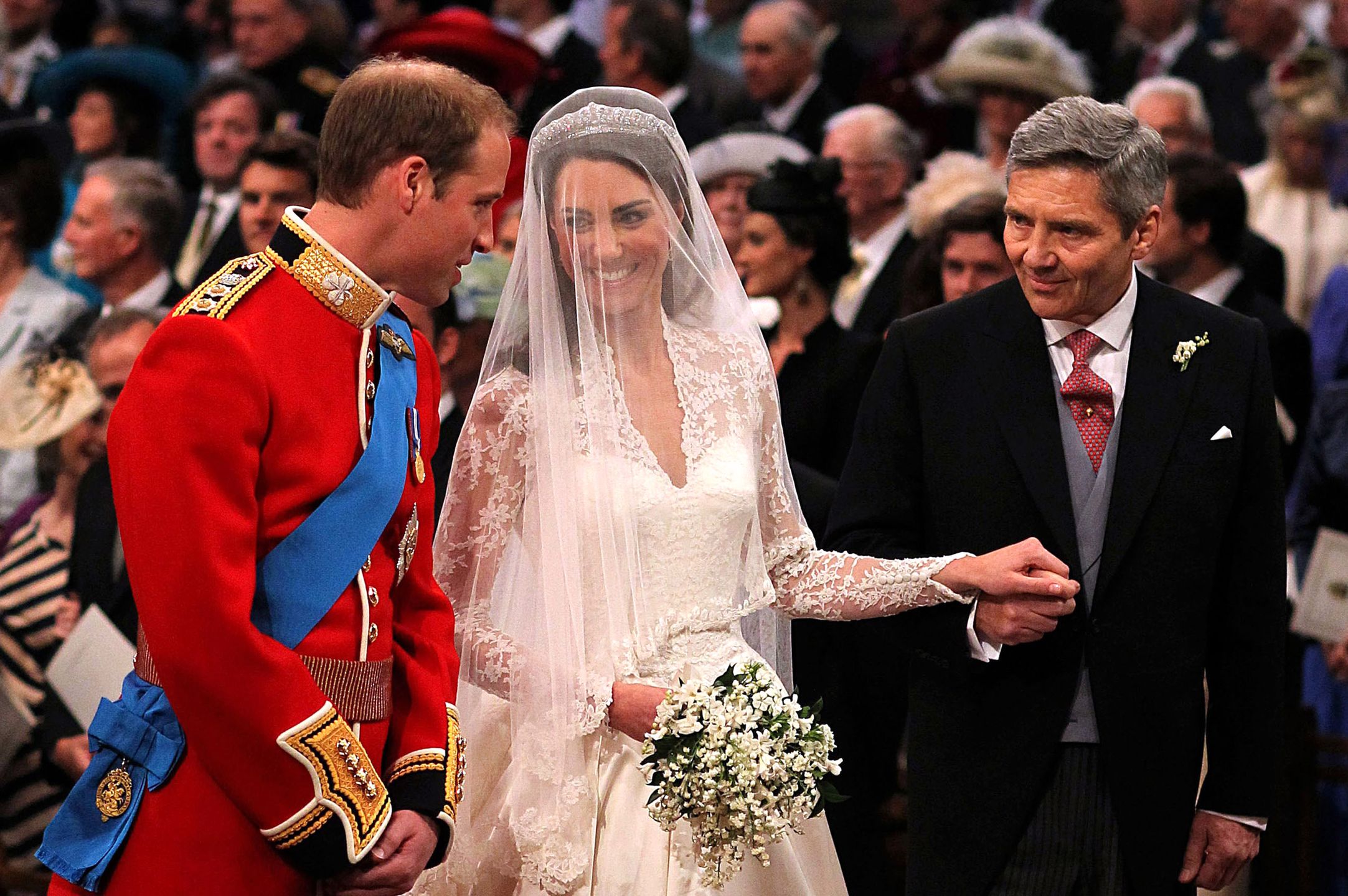 LONDON, ENGLAND - APRIL 29: Prince William speaks to his bride, Catherine Middleton as she holds the hand of her father Michael Middleton at Westminster Abbey on April 29, 2011 in London, England.  The marriage of Prince William, the second in line to the British throne, to Catherine Middleton is being held in London today. The marriage of the second in line to the British throne is to be led by the Archbishop of Canterbury and will be attended by 1900 guests, including foreign Royal family members and heads of state. Thousands of well-wishers from around the world have also flocked to London to witness the spectacle and pageantry of the Royal Wedding.  (Photo by Dominic Lipinski - WPA Pool/Getty Images) 