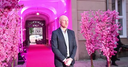 Elegancki Krzysztof "Diablo" Włodarczyk z zabandażowanym palcem pozuje na ściance