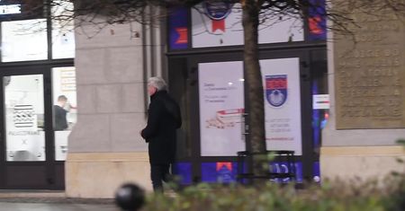 Urbański ukryty za plastikowymi skrzynkami sączy piwo