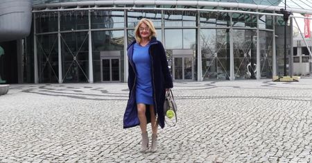 Elegancka Majka Jeżowska w długim płaszczu prezentuje nagą łydkę