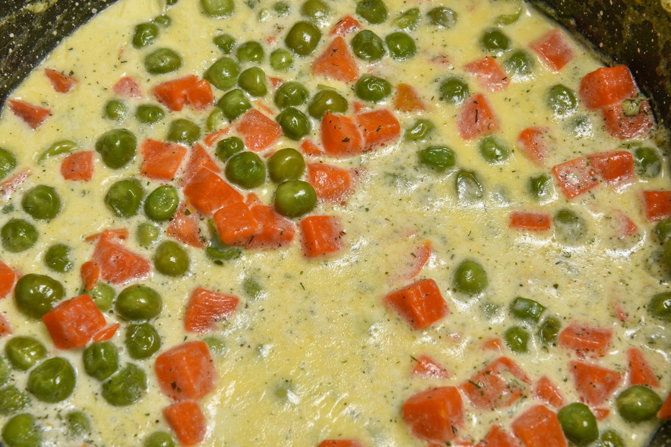 Green peas stewed with orange carrots in creamy milk white sauce, vegetable stew 