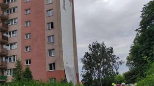 Silne porywy wiatru zerwały elewację bloku. Na miejscu działa straż pożarna