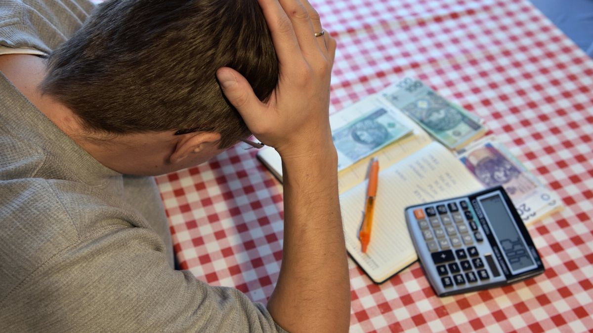 Stock BaMaFot. Bartlomiej Magierowski/East News. Wroclaw 17.11.2022. Wysoka inflacja, coraz wieksze wydatki na zycie. N/z: zalamany mezczyzna, pieniadze, kalkulator i notes.Bartlomiej Magierowski