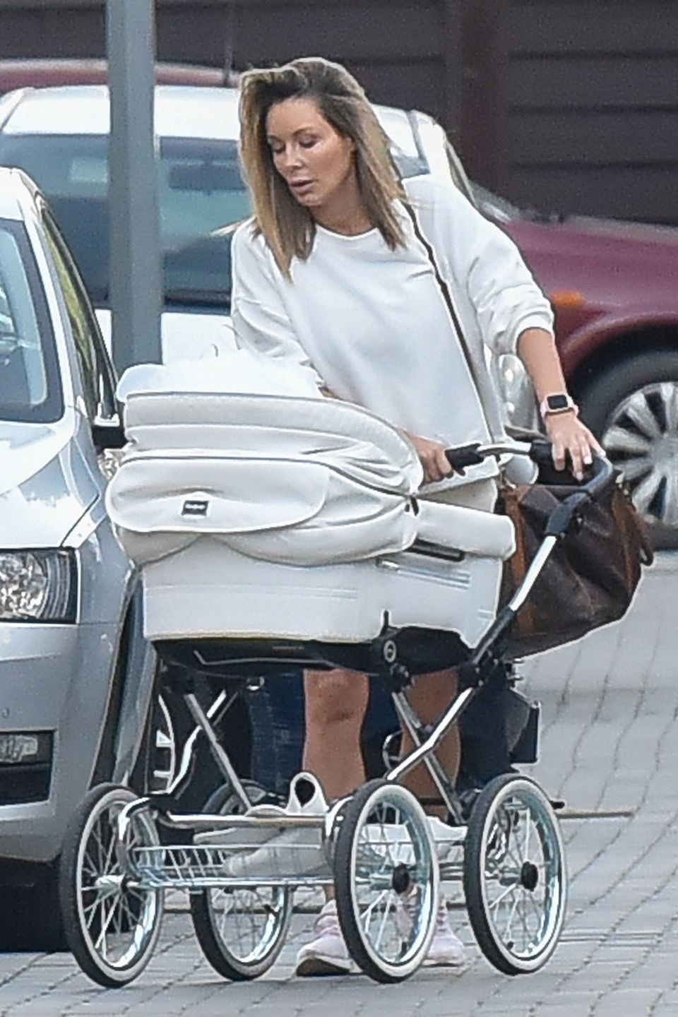 Zaaferowana Małgosia Rozenek sunie wózkiem przez parking