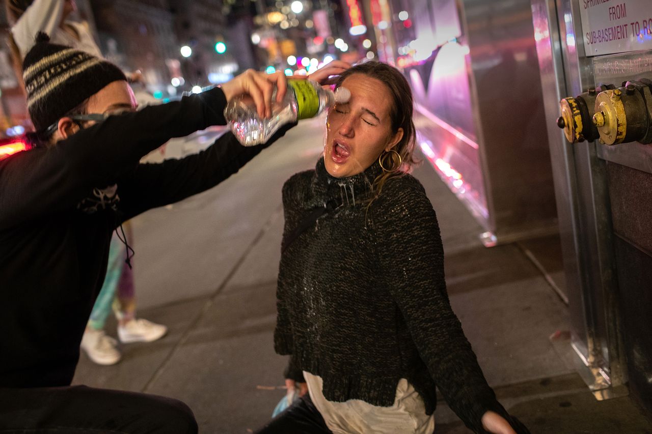 Nowy Jork. Jeden z protestantów pomaga 22-letniej Maire Kelly po tym, jak została spryskana gazem pieprzowym.