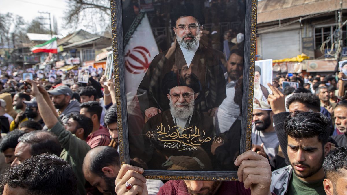 BUDGAM, JAMMU AND KASHMIR, INDIA - 2026/03/13: A Muslim man carrying a frame bearing portraits of the late Iranian Supreme Leader Ayatollah Ali Khamenei and his son newly appointed Iranian Supreme Leader Mojtaba Khamenei during a protest rally marking Al Quds Day in Budgam, south-west of Srinagar. People took to the streets across parts of Kashmir in demonstrations expressing solidarity with Palestine and Iran and anger toward the United States and Israel to mark Al Quds Day, while also mourning and protesting the reported killing of Iran's Supreme Leader Ayatollah Ali Khamenei, who was killed in a joint U.S. Israeli strike in Tehran on February 28, 2026. Al Quds Day is observed globally on the last Friday of the holy month of Ramadan, known as Jumat ul Vida, with rallies held around the world to express solidarity with Palestinians and opposition to the Israeli occupation of Jerusalem. The annual observance was established in 1979 by Ayatollah Ruhollah Khomeini, the founder of the Islamic Republic of Iran, shortly after the Iranian Revolution. (Photo by Faisal Bashir/SOPA Images/LightRocket via Getty Images)