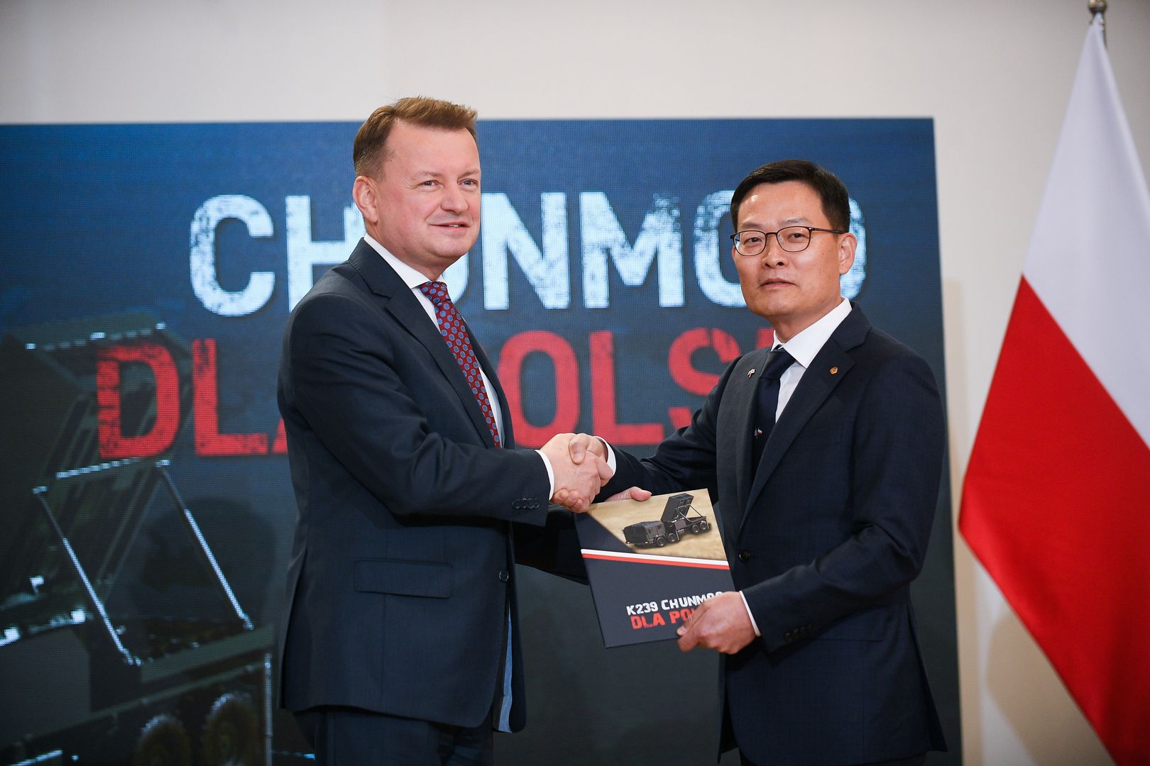 Warszawa, 19.10.2022. Wicepremier, minister obrony narodowej Mariusz Błaszczak (L) oraz prezes Koncernu Hanwha Defense Jaeil Son (P) podczas uroczystości podpisania umowy na koreańskie wyrzutnie Chunmoo, 19 bm. w siedzibie Departamentu Wojskowych Spraw Zagranicznych Ministerstwa Obrony Narodowej w Warszawie. (ad) PAP/Marcin Obara