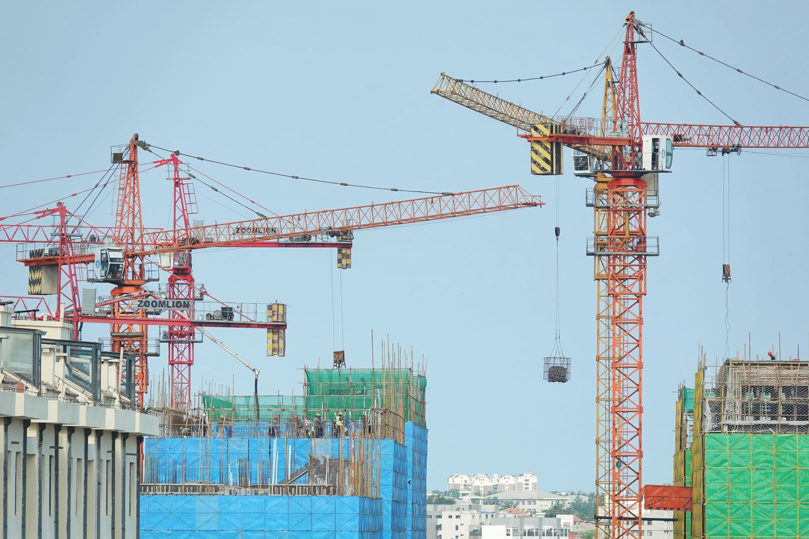 YANTAI, CHINA - JULY 23, 2024 - Tower cranes are seen at a real estate construction site in Yantai, Shandong province, China, July 23, 2024. On July 15, 2024, the National Statistics released the basic situation of the national real estate market from January to June. From January to June, the investment in real estate development nationwide was 5,252.9 billion yuan, down 10.1 percent year on year; Among them, residential investment was 3,988.3 billion yuan, down 10.4%. (Photo credit should read CFOTO/Future Publishing via Getty Images)
