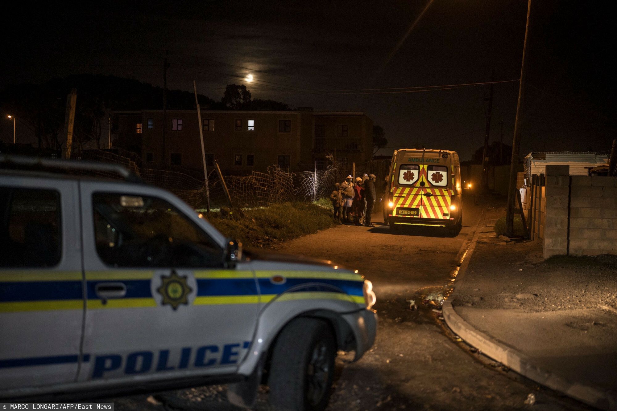Patrol medyczny w Cape Town w RPA - AFP
A patrol car of the South African Police Service provides escort to an ambulance with the Southern Division paramedic at Mitchells Plain EMS base intervening during a night shift duty in the Philippi township, Cape Town, within the broader Cape Flats area, on April 15, 2025. Cape Town?s Emergency Medical Services (EMS) refuses to allow its medical crews to move without security cover when they operate in Red Zones.
The Cape Flats, low-lying townships outside Cape Town, are hotspots for murder and gang violence in a country already plagued by one of the highest crime rates in the world.
Ambulance crews are soft targets for criminals looking to steal phones, money or medical equipment, said Pastor Craven Engel who runs a gang violence prevention organisation called Ceasefire. (Photo by MARCO LONGARI / AFP)
MARCO LONGARI