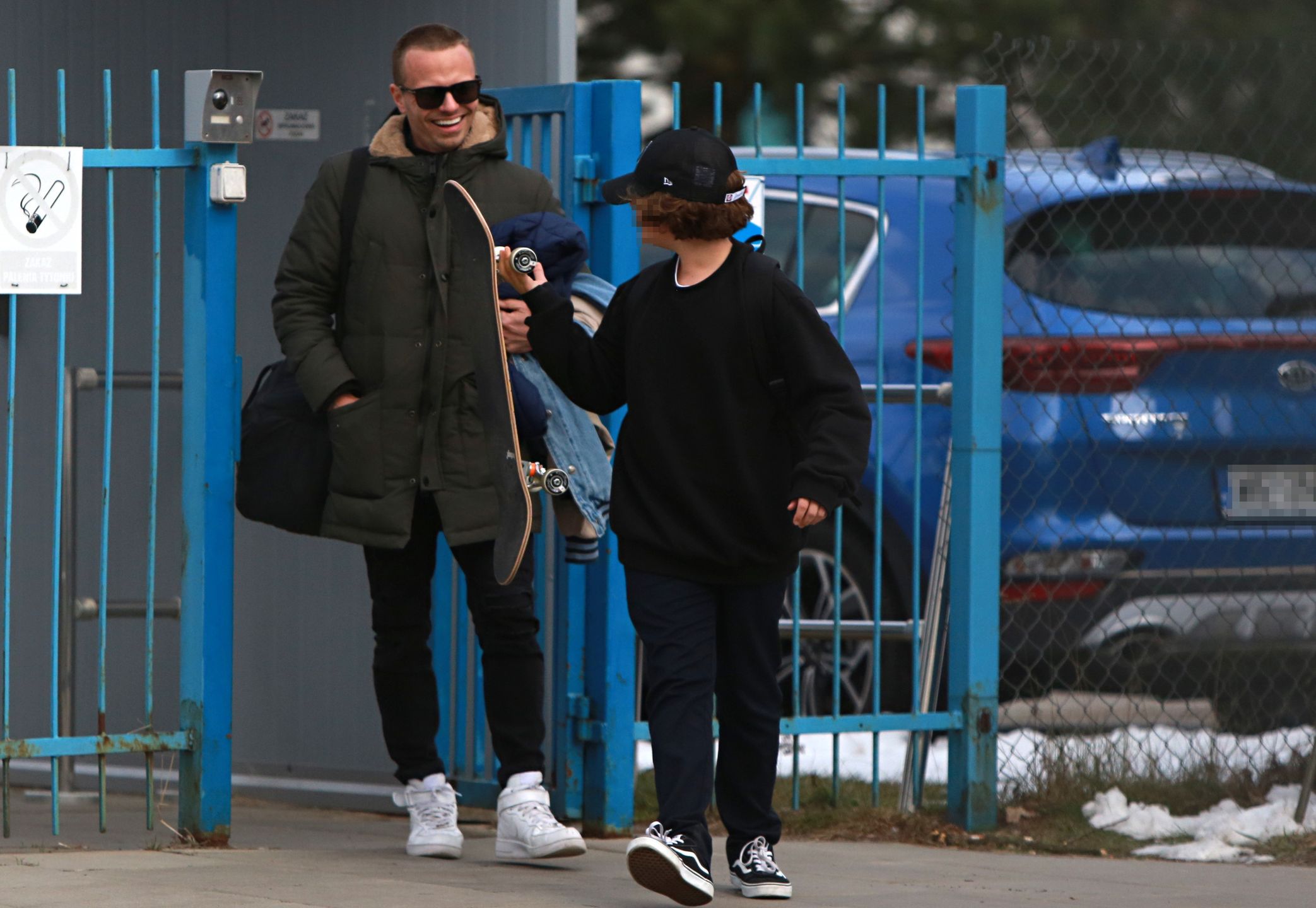 Marcin Hakiel dokazuje z dziećmi na placu zabaw