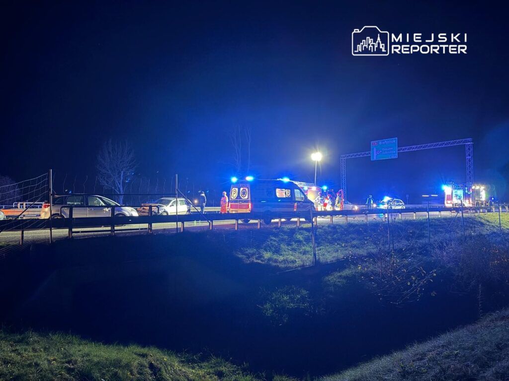 Na drodze w nocy zespół ratunkowy udziela pomocy poszkodowanym w wypadku drogowym.