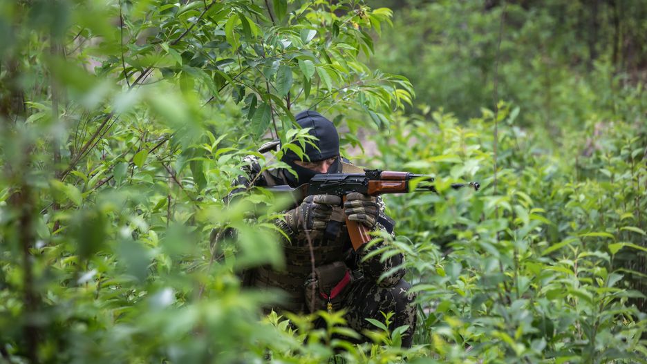 BUCHA, UKRAINE - 2022/06/17: Territorial defense fighter with an automatic rifle in a combat position during combat training. Members of the Bucha territorial defence unit, a support force to the regular Ukrainian army, take part in an exercise for the regular combat tactics classes, not far from the Ukrainian town of Bucha, Kyiv region, Ukraine. (Photo by Mykhaylo Palinchak/SOPA Images/LightRocket via Getty Images)