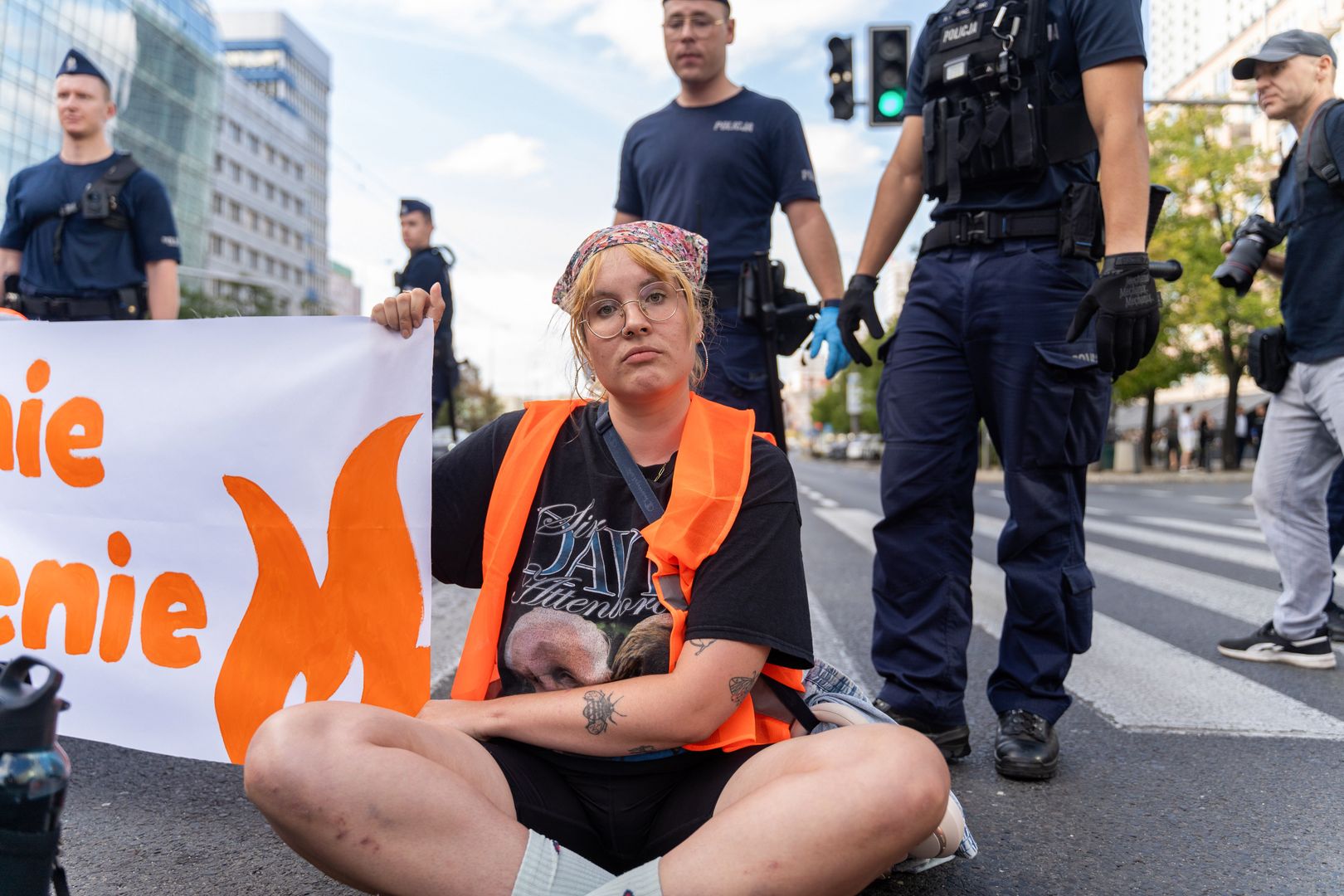 WARSAW, POLAND - 2024/09/11: An activist wearing an orange vest holds a banner that reads: "Last Generation" during the demonstration. The environmental group Last Generation (Ostatnie Pokolenie) staged a protest on Marszalkowska Street in central Warsaw to coincide with the beginning of the school year. Wearing orange vests, the activists called for urgent climate action and structural changes to safeguard the future of younger generations. Their demonstration, aimed at raising awareness about the climate crisis, disrupted traffic to emphasize the immediate need for government intervention. This action is part of Last Generation's broader campaign advocating for climate justice and a sustainable future. (Photo by Marek Antoni Iwanczuk/SOPA Images/LightRocket via Getty Images)