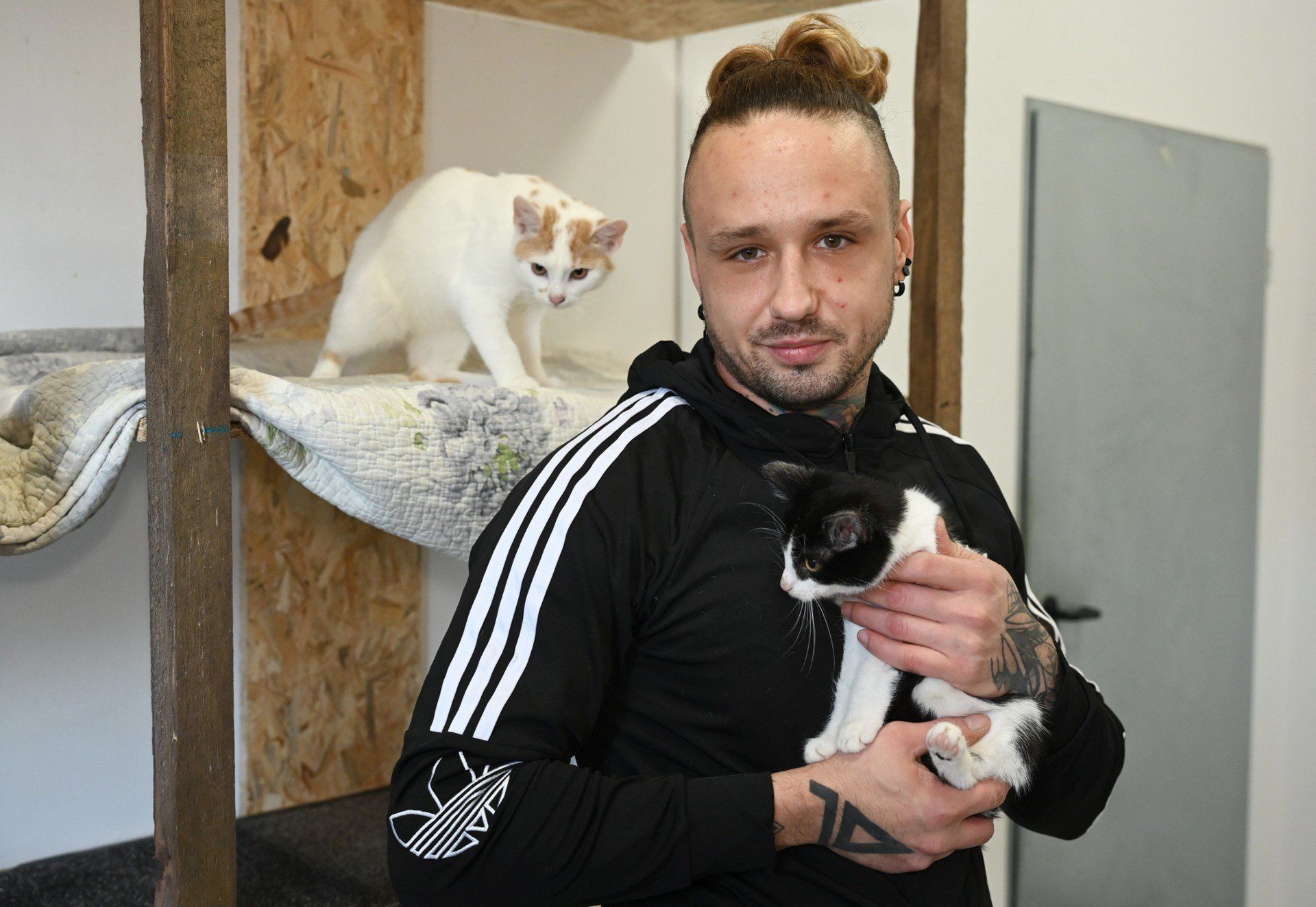 Na zdjęciu Patryk Walkowiak z kotami: Mortim (biało-rudym) oraz Marcinkiem (biało-czarnym).