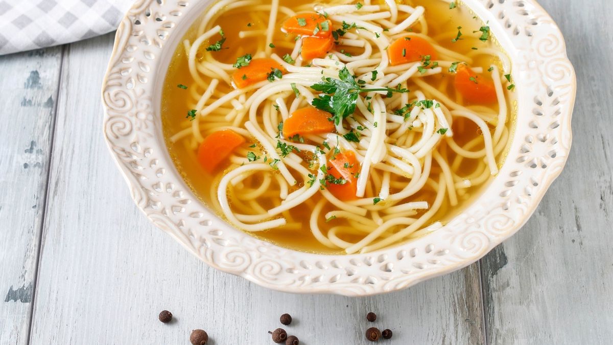 Domowy rosół w białym talerzu