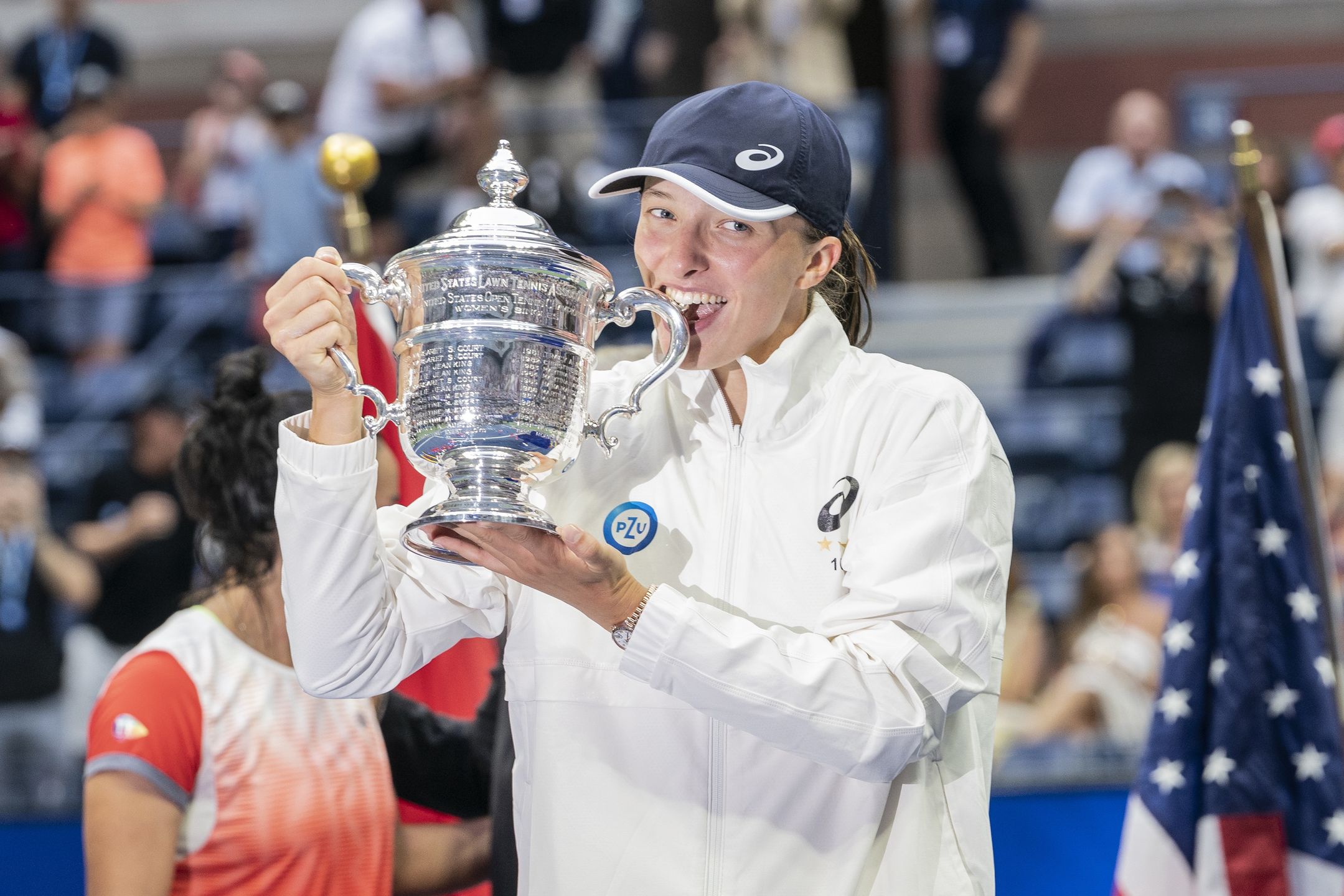 NEW YORK, USA - SEPTEMBER 10: Iga Swiatek of Poland bites the trophy after victory in final of US Open Championships against Ons Jabeur of Tunisia at USTA Billie Jean King National Tennis Center in New York on September 10, 2022. Swiatek won in straight sets. It was her second Grand Slam victory in this year and first ever for Polish woman. (Photo by Lev Radin/Anadolu Agency via Getty Images)