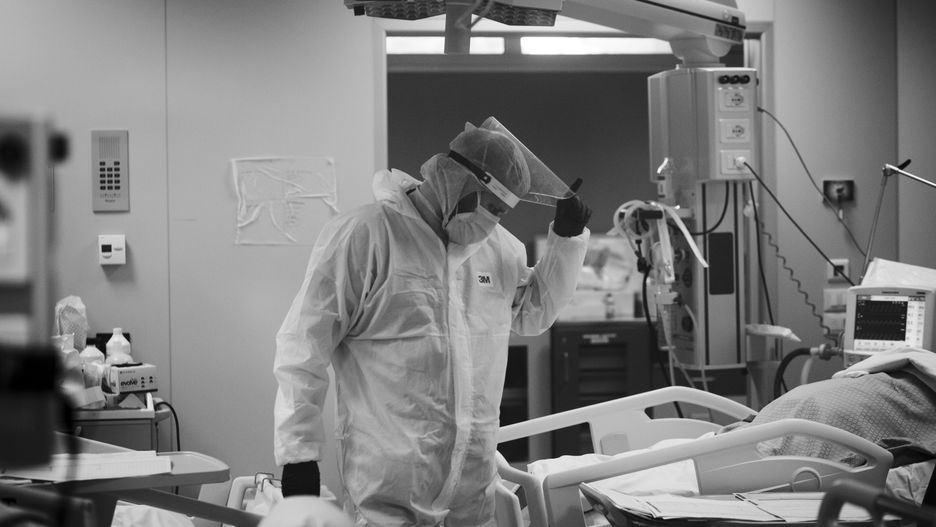 (EDITOR'S NOTE: IMAGE HAS BEEN CONVERTED TO BLACK AND WHITE) A medical worker in personal protective equipment (PPE) tends to a patient in the COVID level-3, Intensive Care Unit (ICU) for novel coronavirus, COVID-19 cases, at the Casal Palocco hospital, near Rome on October 26, 2020. .According to Ministry of Health there has been 21,273 infections from Covid-19 in the last 24 hours out of 161,880 tampons carried out. 128 deaths and 80 additional patients admitted to intensive care units. (Photo by Christian Minelli/NurPhoto via Getty Images)