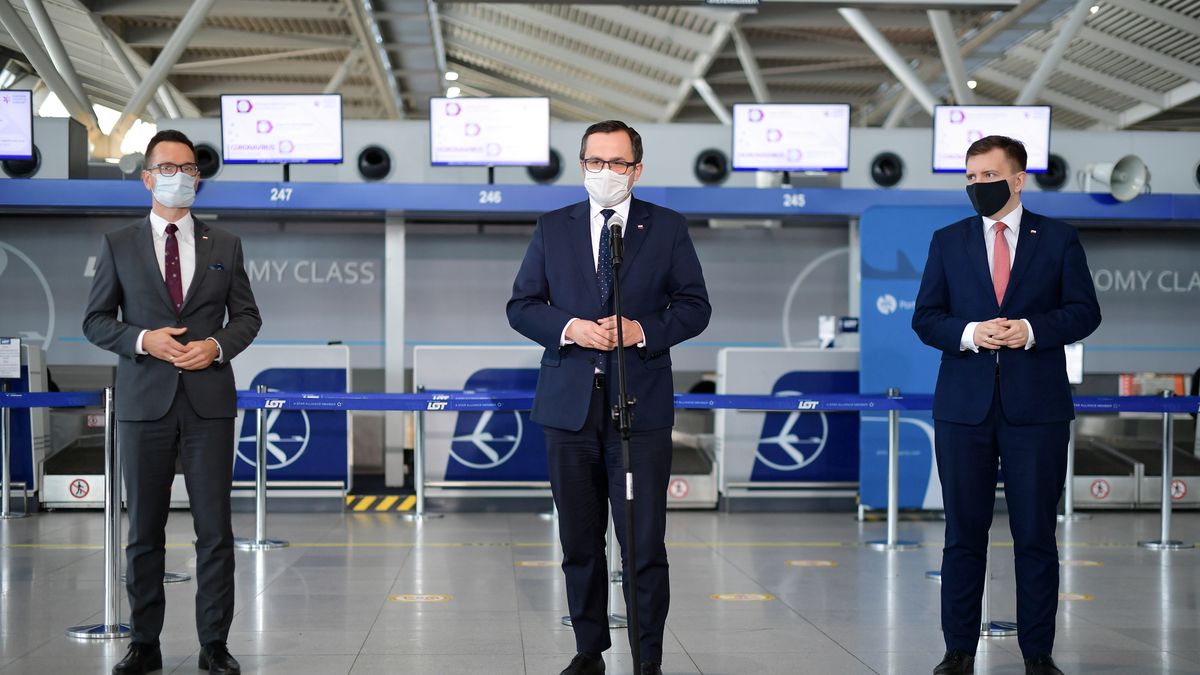 Marcin Horała (w środku) o wsparciu lotnisk poinformował w warszawskim porcie lotniczym.