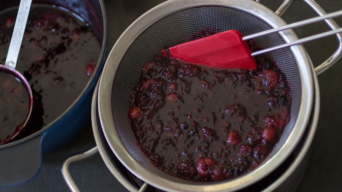 Preparing  jam from berries, part six of eight
Preparing jam or marmalade from berries. Part of a series, six of eight. Gooseberries, black currents, currents. blackberry, lemon, and sugar are boiled and in a sieve for sifting. A red spatula and a sieve placed on a cooking pan. At the left a big pan with the rest of the boiled jam or marmalade.
AnnekeDeBlok