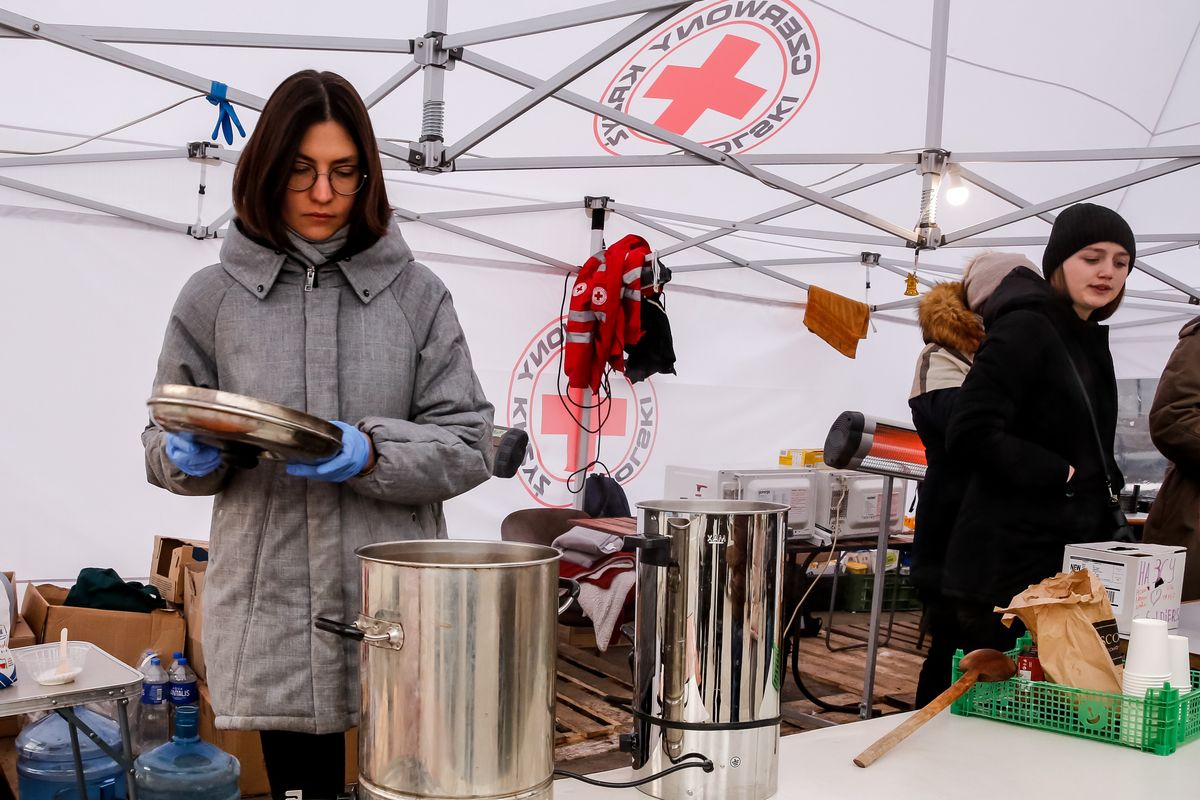 Ukrainian women representing the Polish Red Cross organization are seen providing humanitarian help at the train station in Lviv, Ukraine April 5, 2022. As the Russian Federation invaded Ukraine, the conflict is expected to force up to 5 million Ukrainians to flee the country. Many of the refugees seek asylum in Poland. Most charitable help in Poland is provided by individuals, NGOs and businesses. (Photo by Dominika Zarzycka/NurPhoto via Getty Images)