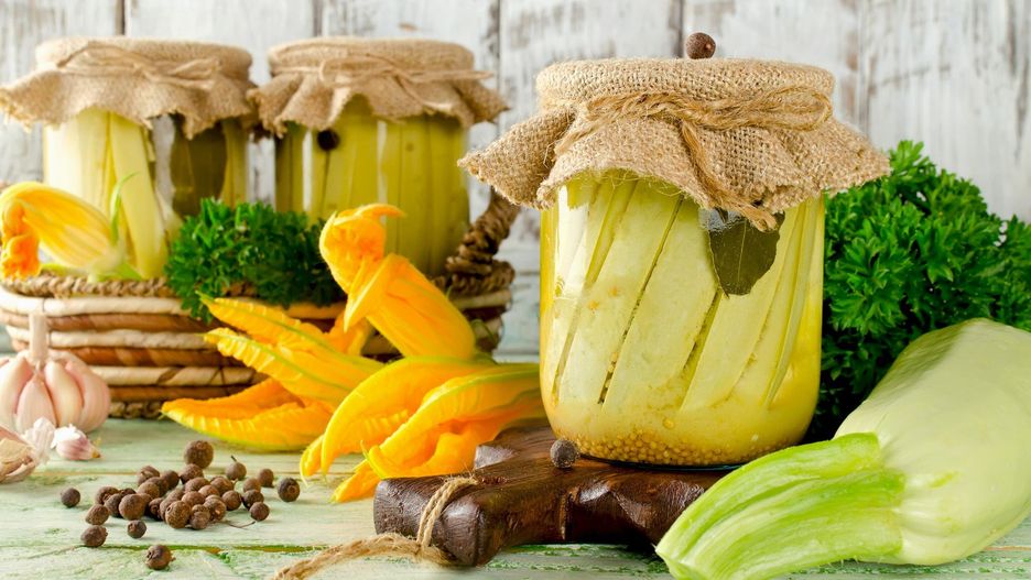 Zucchini preserve in glass jar on a wooden table