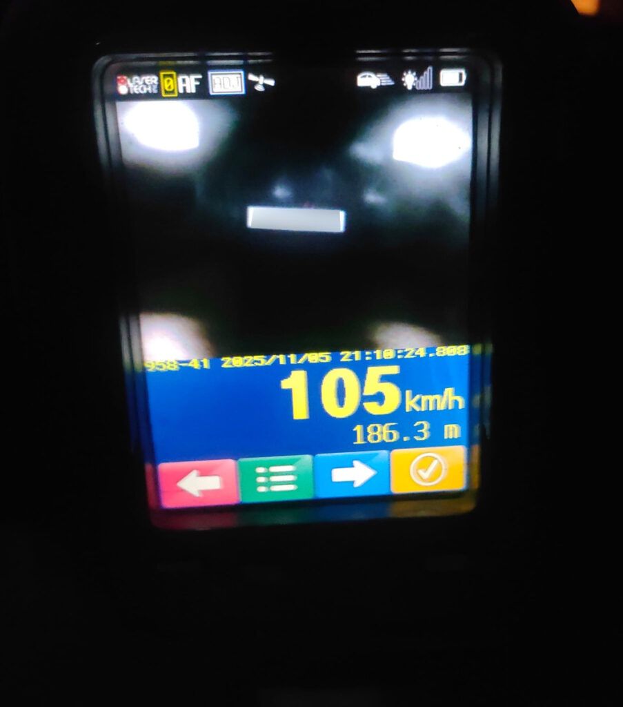 Wyświetlacz urządzenia pomiarowego pokazujący prędkość 105 km/h oraz odległość 186,3 m.