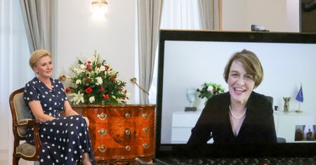 Rozpromieniona Agata Duda z nogą założoną na nogę wygląda olśniewająco