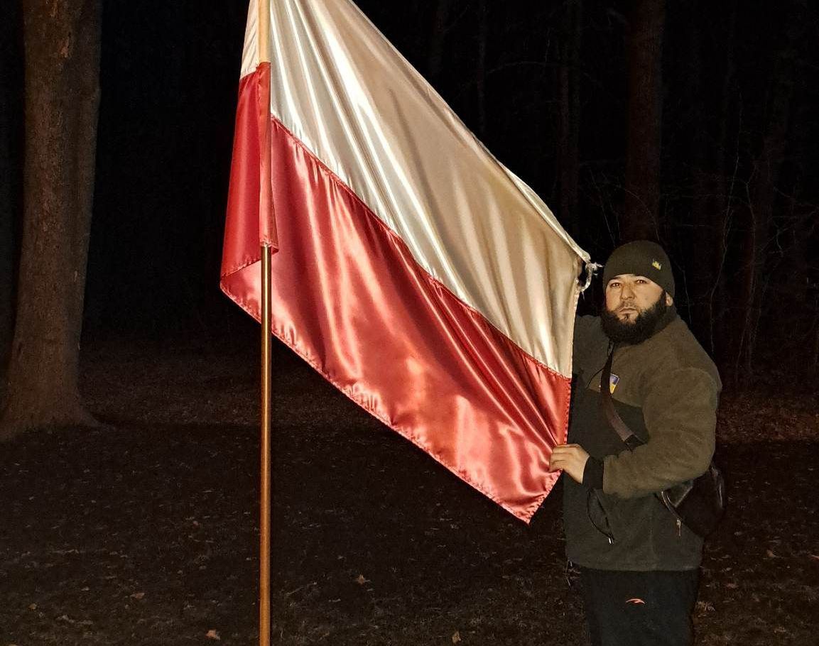 Czeczeński bojownik z polską flagą na Cmentarzu Ofiar Totalitaryzmu. 22 marca 2023 roku
