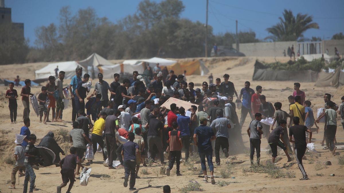 DEIR AL-BALAH, GAZA - JULY 31: Palestinians rush to collect humanitarian aid dropped by parachute in the Al-Zawaida area of Deir al-Balah, Gaza Strip, on July 31, 2025. The airdrops come amid a severe humanitarian crisis in Gaza, where months of Israeli blockade have left the population facing acute food shortages. (Photo by Hassan Jedi/Anadolu via Getty Images)