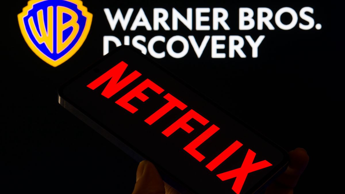 The Netflix logo is displayed on a mobile phone with Warner Bros. Discovery in the background, in this photo illustration in Brussels, Belgium, on December 9, 2025. (Photo by Jonathan Raa/NurPhoto via Getty Images)